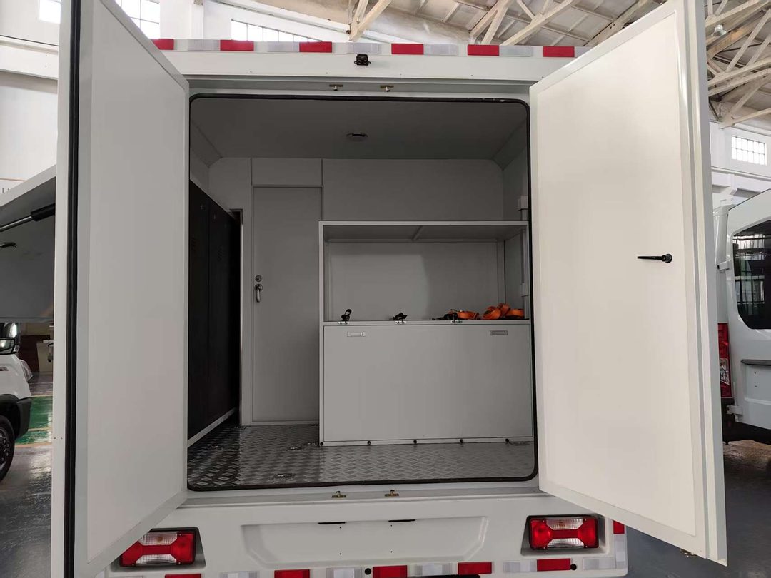 Rear compartment of a command vehicle with workbench and equipment racks — the working space the layout has to leave clear
