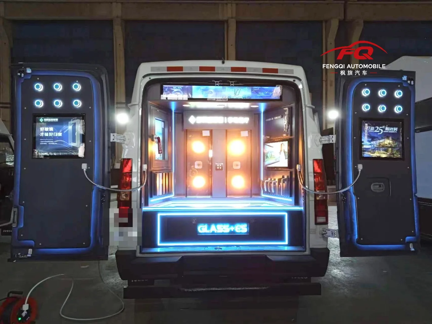 Rear doors open on the completed demonstration van, showing illuminated product displays and screens